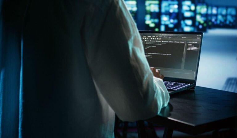 Programmer securing sportsbook platform data with laptop in server room